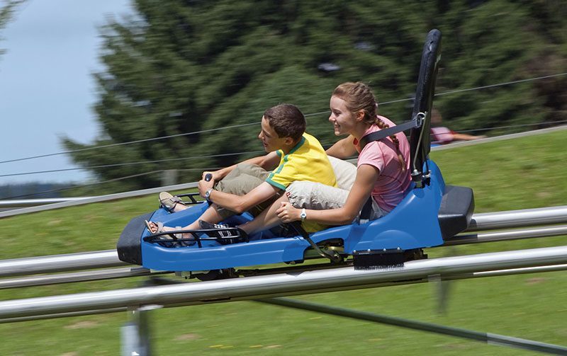 Zwei glückliche Menschen auf einer Sommerrodelbahn in St. Englmar